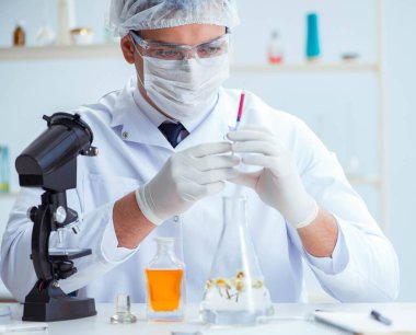 Laboratuvarda parfüm karıştıran bir kimyager.