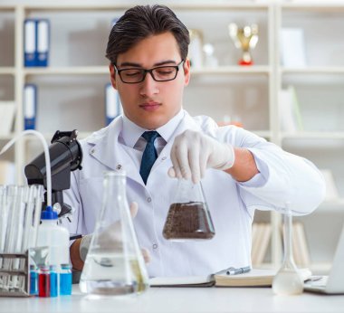 Genç araştırmacı bilim adamı bir su testi kirliliği araştırması yapıyor.