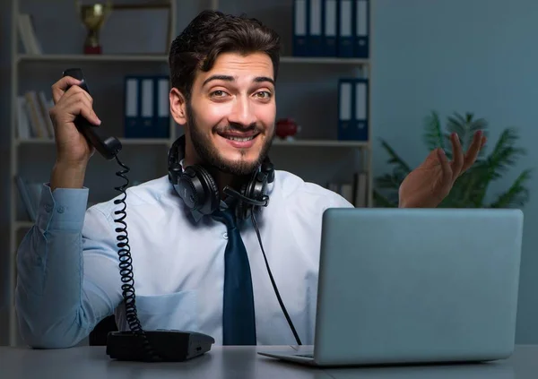コールセンターのコンセプトの若い男は、オフィスで残業を遅く働く — ストック写真