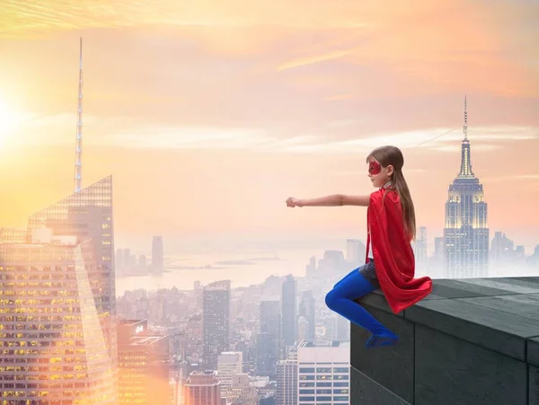 Młoda dziewczyna w stroju superbohatera z widokiem na miasto — Zdjęcie stockowe