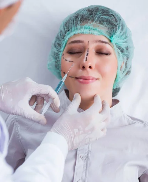 Chirurg plastyczny przygotowujący się do operacji na kobiecej twarzy — Zdjęcie stockowe