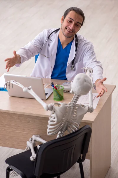 Joven doctor y paciente esqueleto en la clínica — Foto de Stock