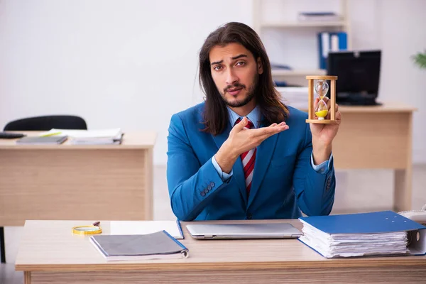 Giovane dipendente maschile nel concetto di gestione del tempo in ufficio — Foto Stock