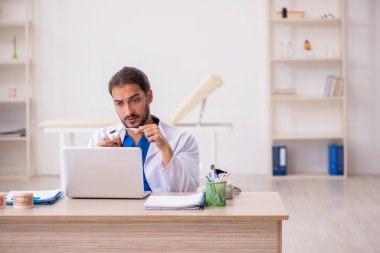 Teletıp konseptinde genç bir erkek odontolog.