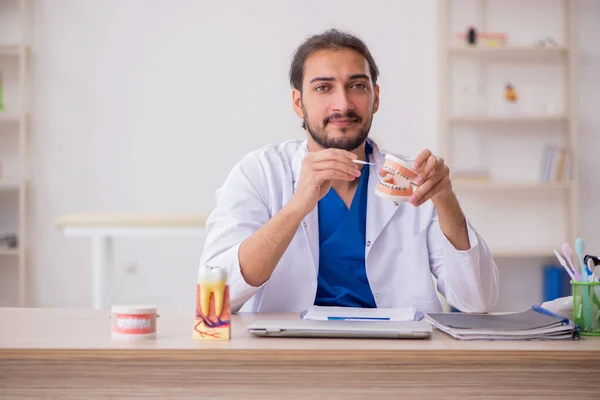 Jonge mannelijke tandarts docent werkzaam in de kliniek — Stockfoto