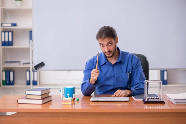 教室に座っている若い男性の先生物理学者 — ストック写真