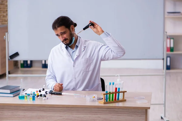 Joven profesor químico sentado en el aula —  Fotos de Stock
