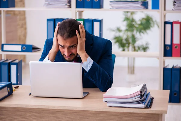 Jeune employé masculin et trop de travail au bureau — Photo