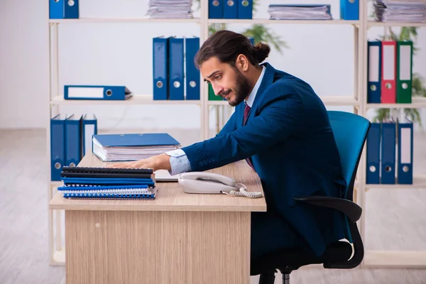 Joven empleado masculino y demasiados trabajan en la oficina — Foto de Stock