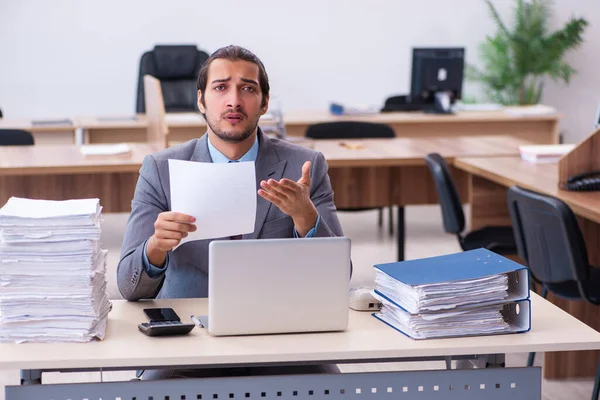 Jovem funcionário masculino infeliz com excesso de trabalho no escritório — Fotografia de Stock