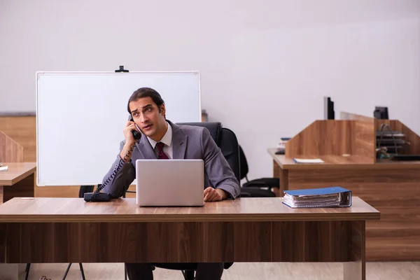 Young male business trainer in the office during pandemic