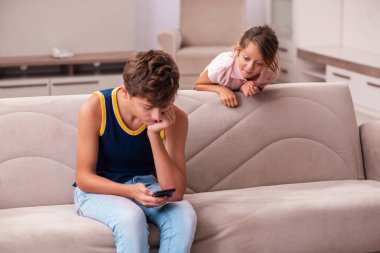 Oğlan ve küçük kız kardeşi salgın sırasında evde kalıyorlar.