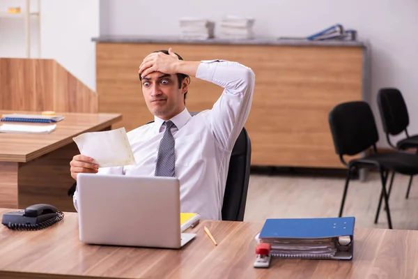 Junge männliche Angestellte unzufrieden mit Bürostreich im Büro — Stockfoto