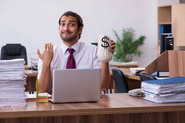 Joven empleado masculino sosteniendo bolsa de dinero en la oficina — Foto de Stock