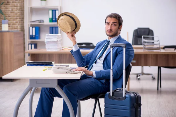 Ung manlig anställd förbereder sig för resa på kontoret — Stockfoto