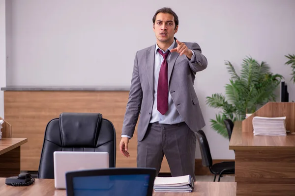 Молодой бизнесмен в концепции запугивания в офисе — стоковое фото