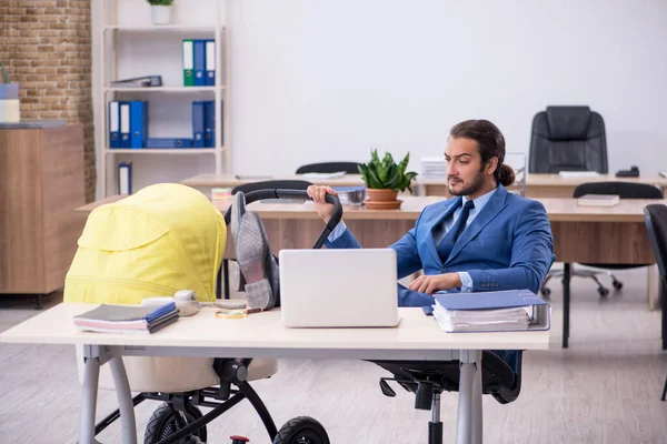 Jeune employé masculin s'occupant d'un nouveau-né sur le lieu de travail — Photo