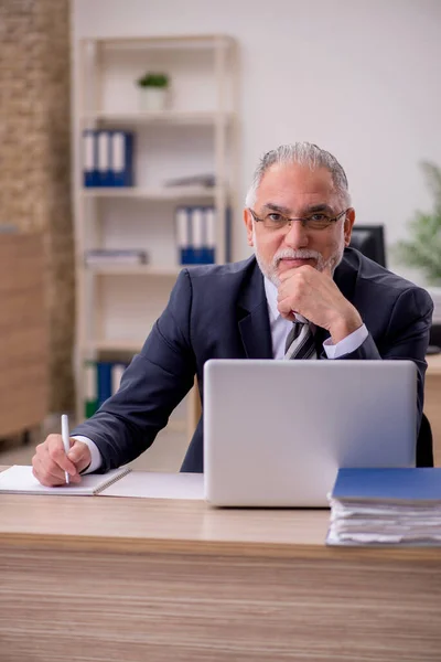 Starší podnikatel zaměstnanec sedí v kanceláři — Stock fotografie