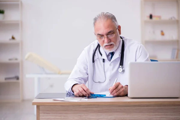 Viejo médico que trabaja en la clínica —  Fotos de Stock