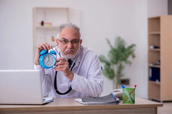 Viejo médico masculino en concepto de gestión del tiempo —  Fotos de Stock