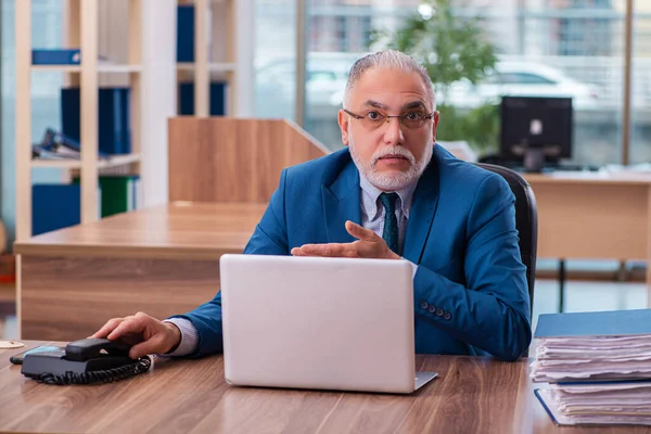 Ancien employé masculin travaillant dans le bureau — Photo