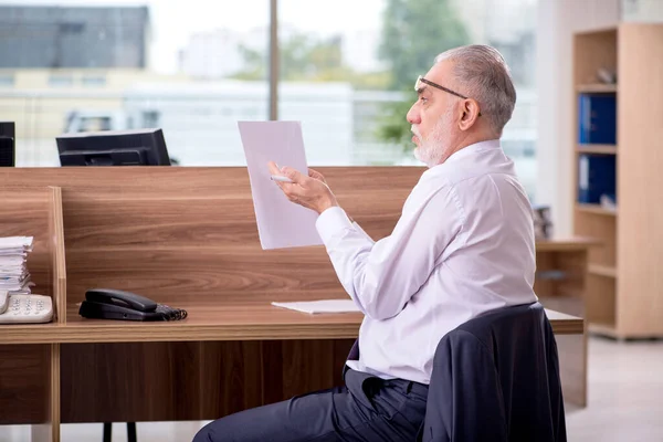 Vecchio dipendente maschio seduto in ufficio — Foto Stock