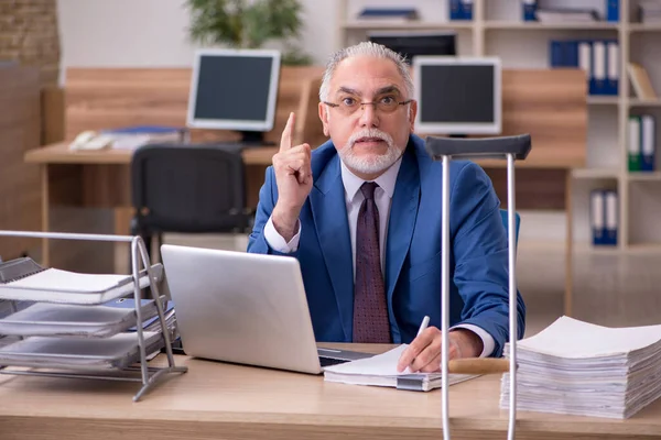 Old businessman employee after accident working in the office — Stock Photo, Image