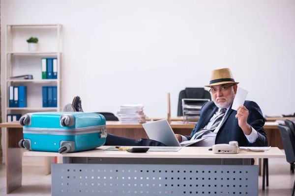 Alte männliche Angestellte bereiten sich im Büro auf die Reise vor — Stockfoto