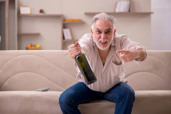 Az öregember otthon iszik alkoholt. — Stock Fotó