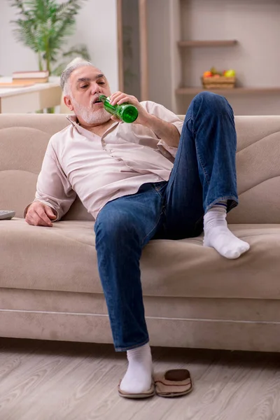 Oude man die thuis alcohol drinkt — Stockfoto
