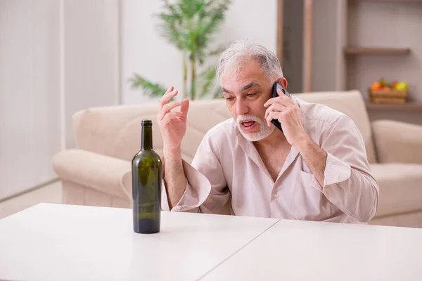 Vieil homme buvant de l'alcool à la maison — Photo