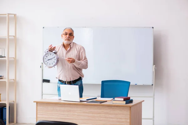 Viejo profesor en el aula en concepto de gestión del tiempo — Foto de Stock