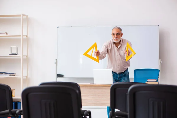 Antigo professor de geometria masculina em sala de aula em conceito pandêmico — Fotografia de Stock