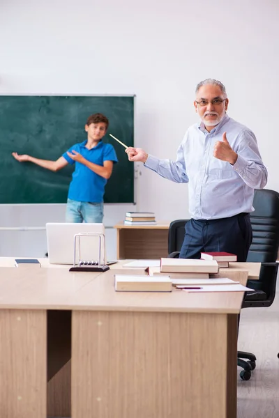 Gammal manlig lärare och skolpojke i klassrummet — Stockfoto