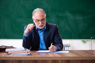 Sınıftaki yaşlı erkek matematik öğretmeni.