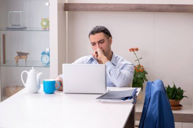 Evde çalışan genç bir erkek.