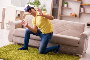 Evde sanal gözlüklü genç bir öğrenci.