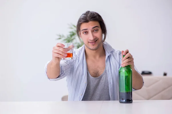 年轻的男性酒鬼在家喝威士忌 — 图库照片