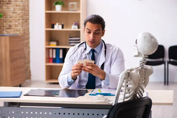Young male doctor cardiologist and skeleton patient in the clini — Stock Photo, Image