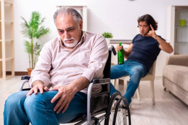 Tekerlekli sandalyedeki yaşlı adam ve genç kötü bakıcı.