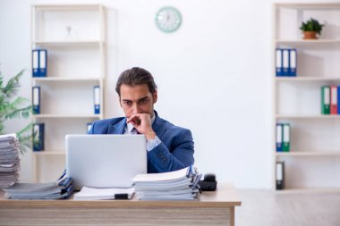 Ofisteki aşırı işten memnun olmayan genç bir erkek işçi.