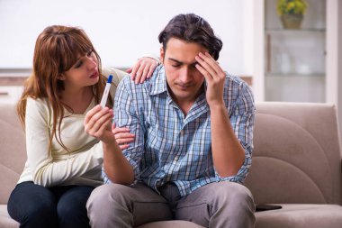 Evde beklenmedik hamilelik konsepti olan genç bir çift var.