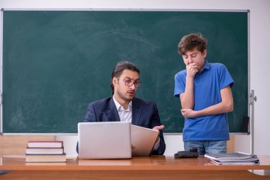 Genç erkek öğretmen ve okul çocuğu sınıfta.