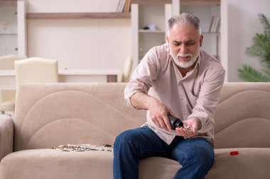 Yaşlı hasta adam evde acı çekiyor.