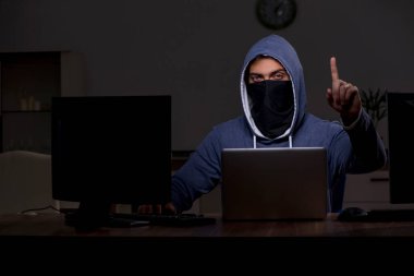 Erkek bilgisayar korsanı, güvenlik duvarını geç saatlerde hackliyor.