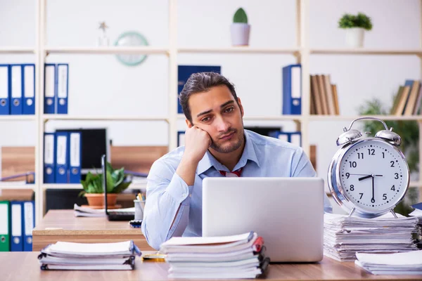 Joven empleado masculino infeliz con el trabajo excesivo en la gestión del tiempo — Foto de Stock