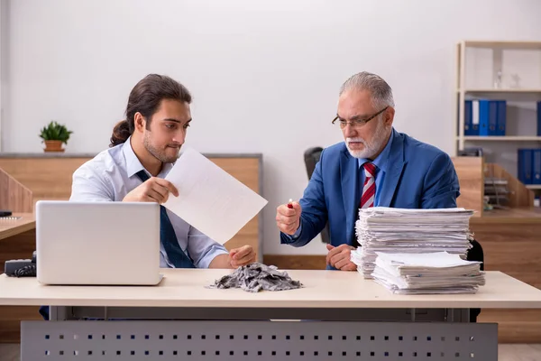 Giovane dipendente maschio e vecchio capo bruciando documenti sul posto di lavoro — Foto Stock