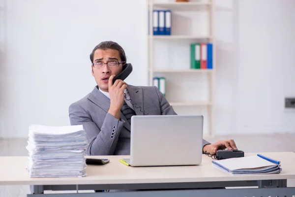 Fiatal férfi alkalmazott beszél telefonon az irodában — Stock Fotó