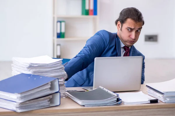 Young male employee unhappy with excessive work in the office — Stock Photo, Image