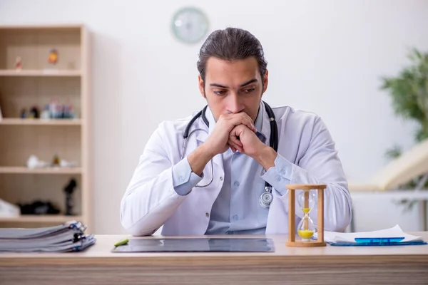 Zaman yönetimi konseptinde genç erkek doktor — Stok fotoğraf